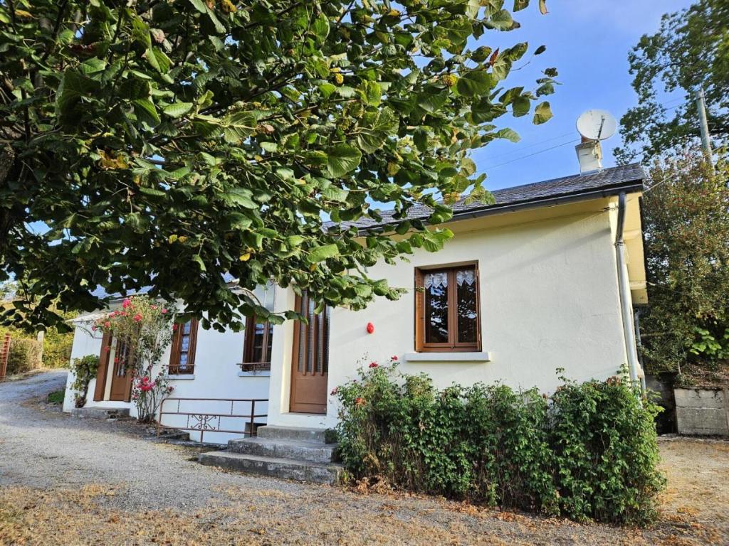 ein kleines weißes Haus mit einem Baum in der Unterkunft Gîte de France à Eygurande 2 épis - Gîte de France 4 personnes 164 in Eygurande