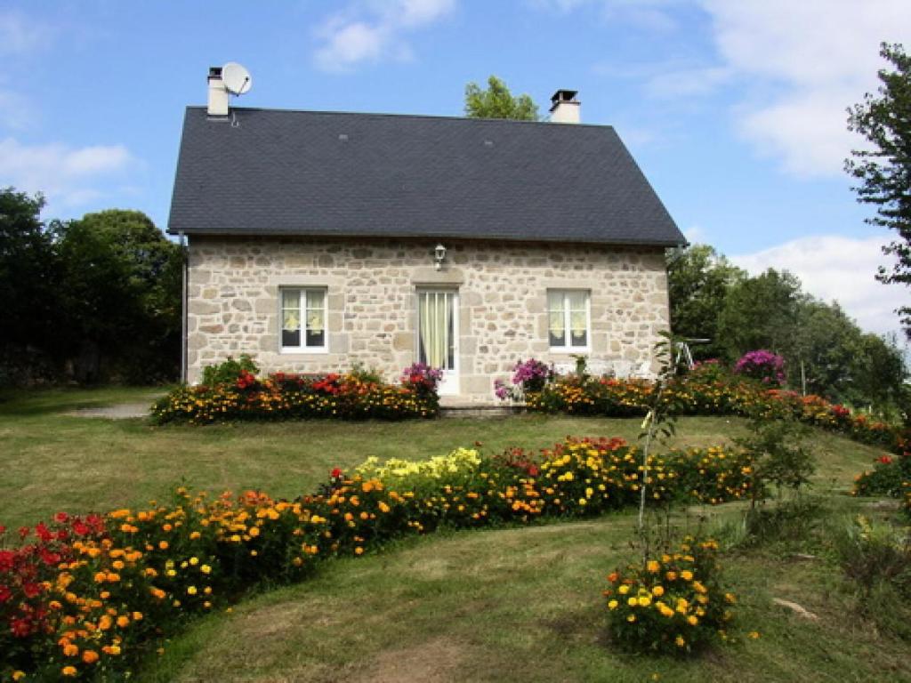 a stone house with flowers in front of it at Gîte de France Chez dédé et léa 3 épis - Gîte de France 6 personnes MAE-9414 in Sarroux