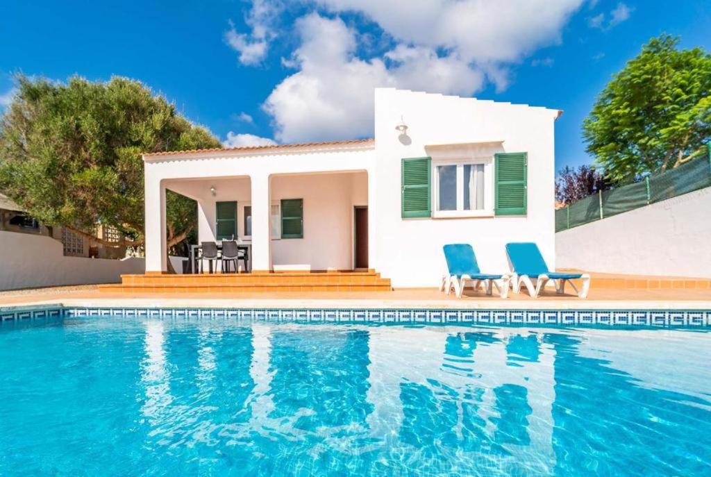 a villa with a swimming pool in front of a house at Villa Patri in Cala'n Porter