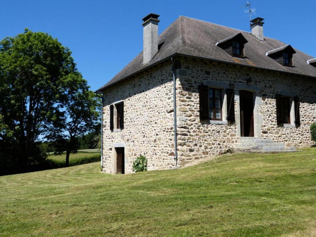 un antiguo edificio de piedra en un campo de césped en Gîte de France à Latronche 2 épis - Gîte de France 6 personnes 454 