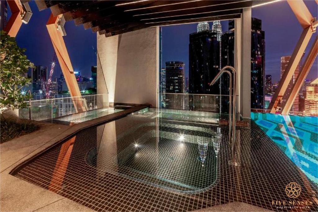 a balcony with a hot tub and a view of a city at Scarletz Suites Kuala Lumpur, Five Senses in Kuala Lumpur