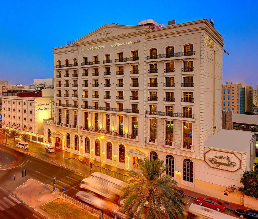 a large white building on a city street with traffic at Royal Ascot Hotel in Dubai