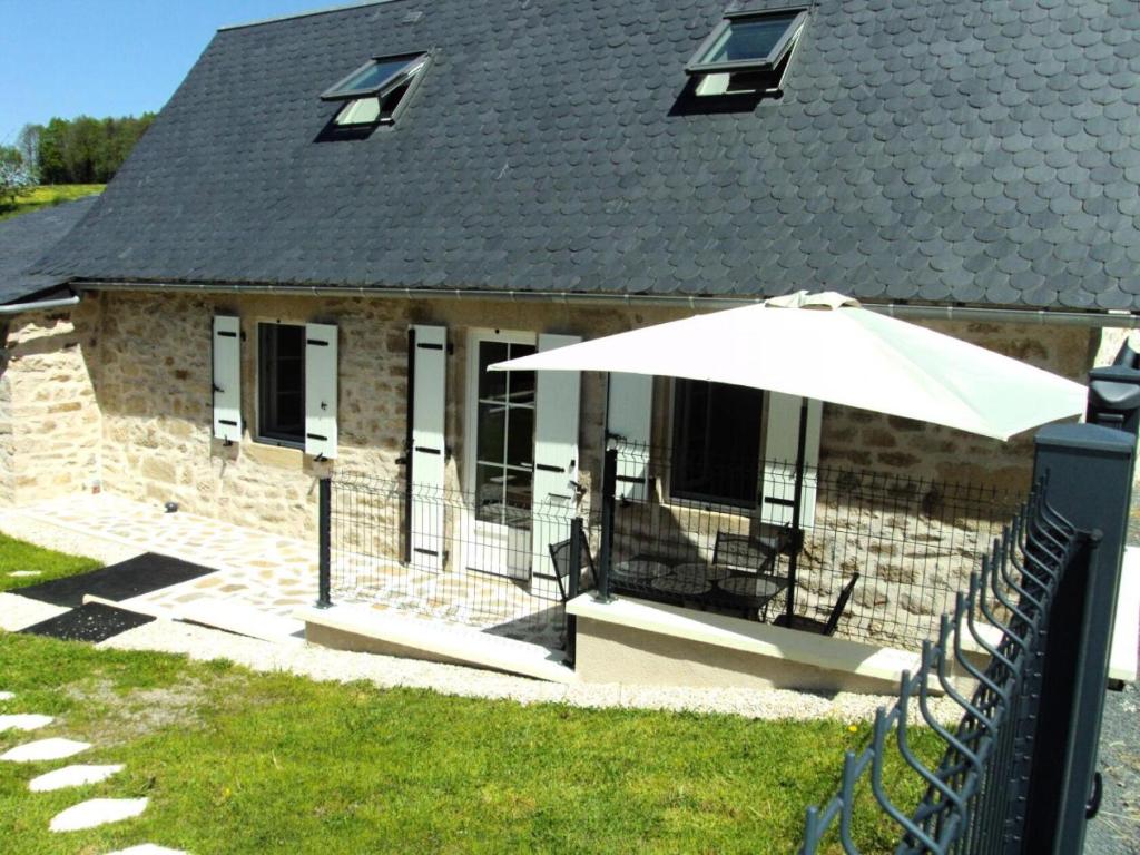 une maison avec un parapluie devant dans l'établissement Gîte de France La maison de thienot 3 épis - Gîte de France 3 personnes MAE-9724, à La Bitarelle
