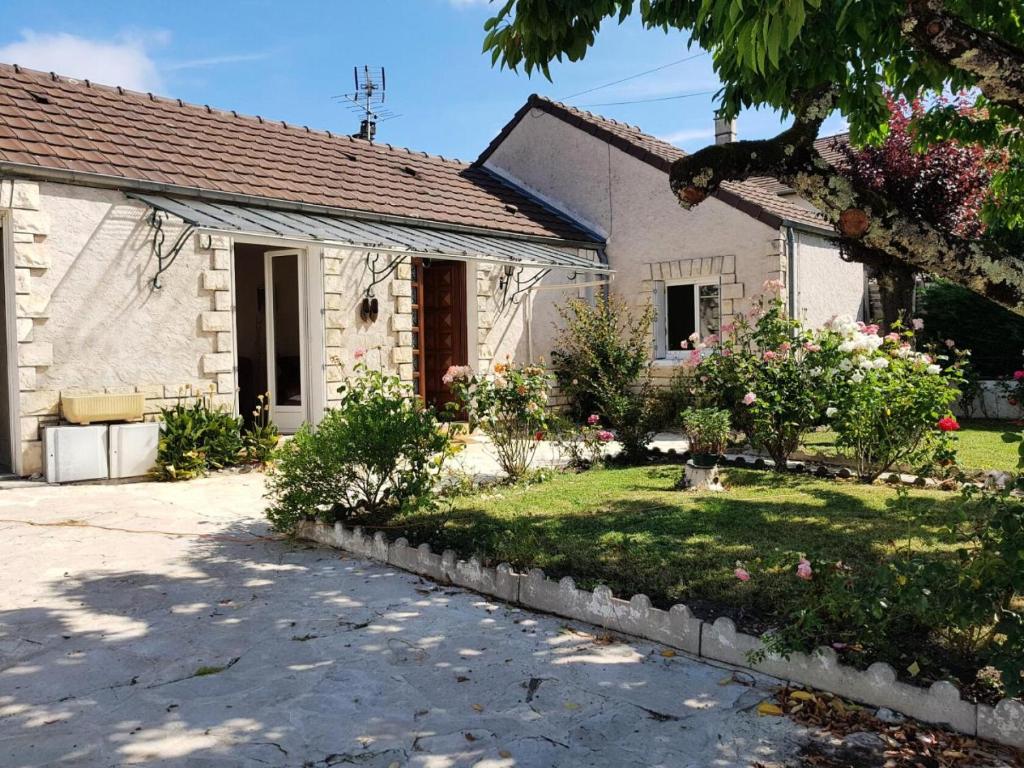 une petite maison blanche avec une cour fleurie dans l'établissement Gîte de France à Brive-la-Gaillarde 3 épis - Gîte de France 4 personnes MAE-9794, à Brive-la-Gaillarde