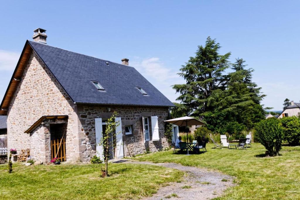 una casa de piedra con techo negro en Gîte de France Fanfou 3 épis - Gîte de France 4 personnes 694, en Saint-Yrieix-le-Déjalat