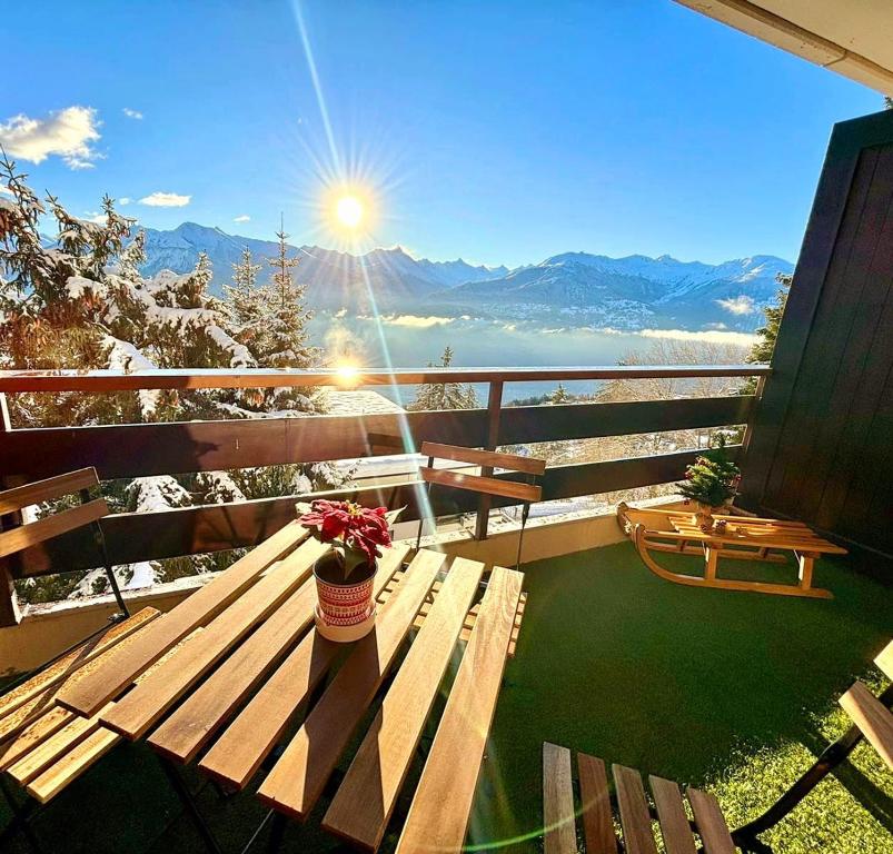 a balcony with a bench and a view of the mountains at Vue imprenable sur les Alpes et Parking privé gratuit in Crans-Montana