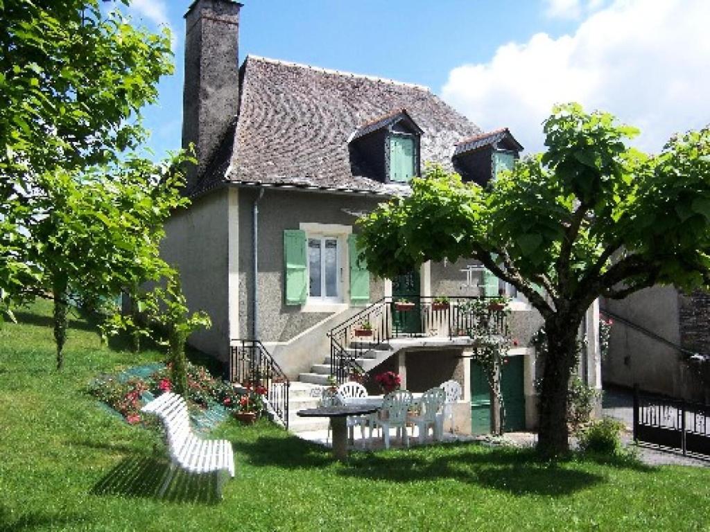 a house with two chairs and a table in the yard at Gîte de France à Allassac 3 épis - Gîte de France 4 personnes MAE-9994 in Allassac