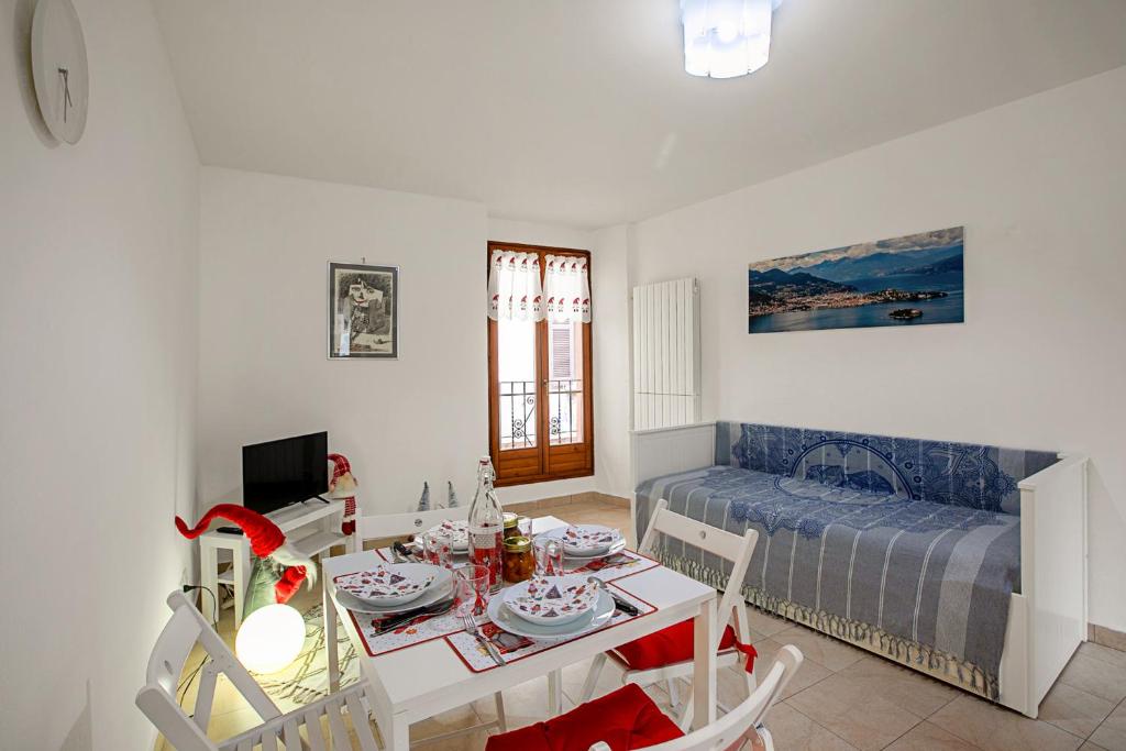 uma sala de estar com uma mesa e uma cama em Lami Apartment Intra Center - Happy Rentals em Verbania