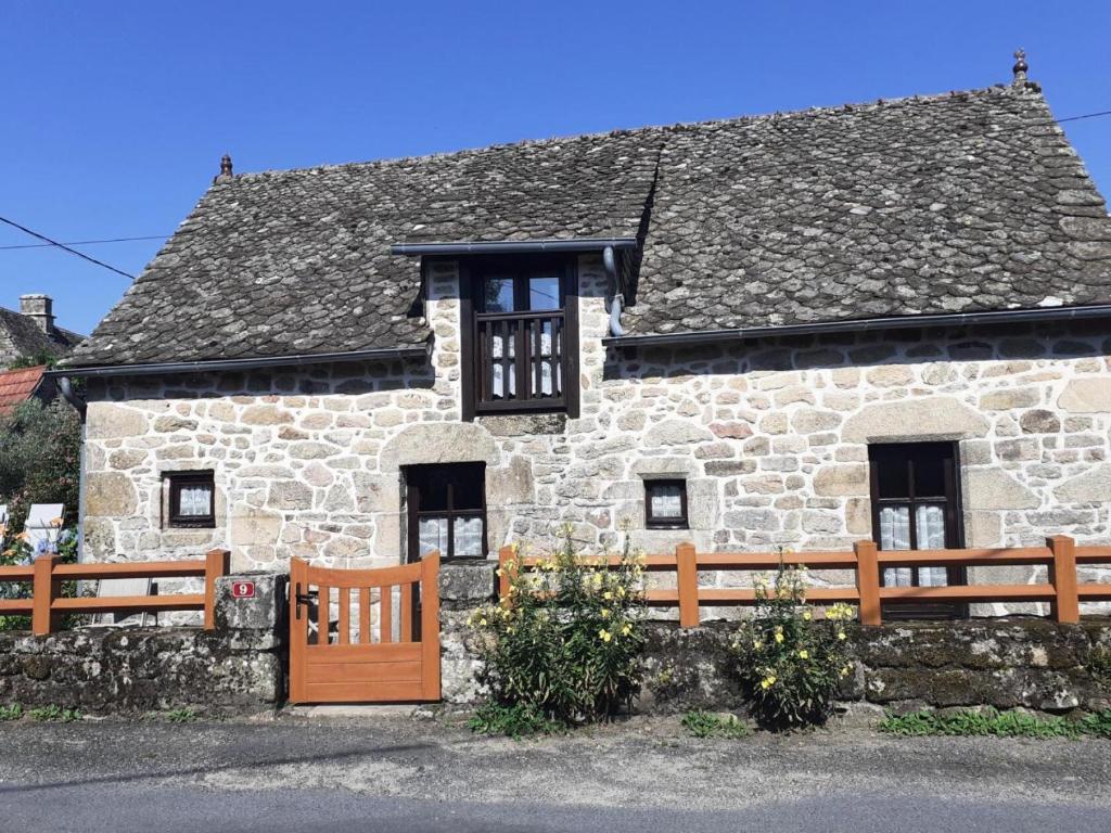 a stone house with a wooden fence in front of it at Gîte de France à Saint-Cirgues-la-Loutre 3 épis - Gîte de France 2 personnes MAE-0054 in Saint-Cirgues-la-Loutre