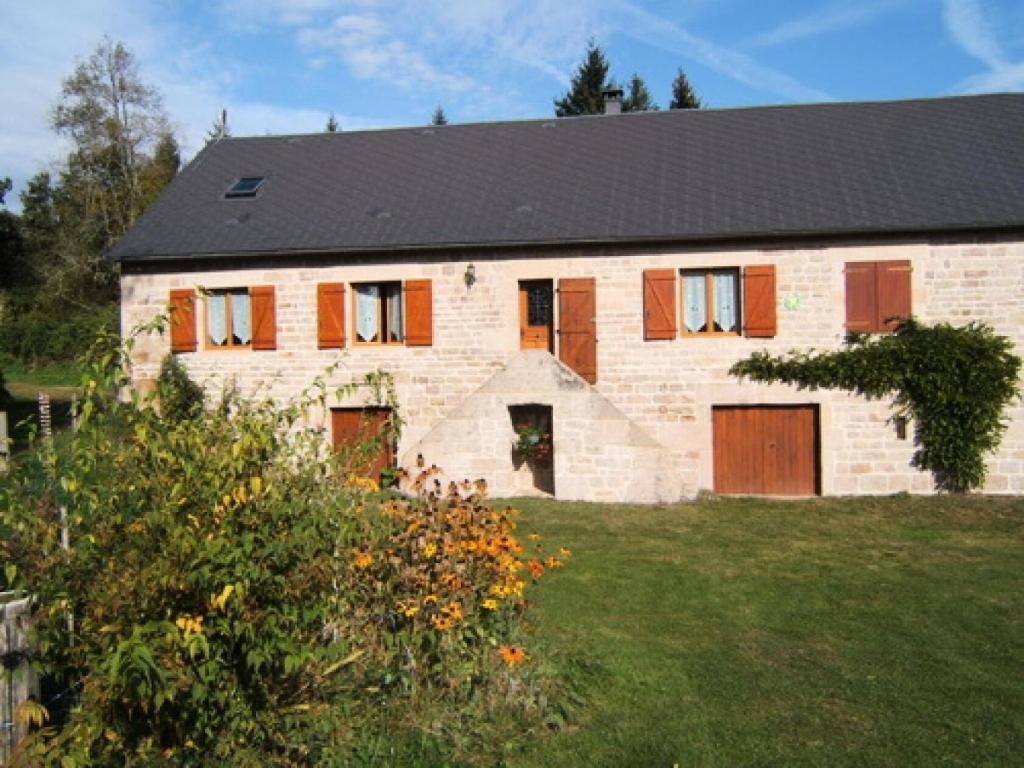una gran casa de ladrillo con techo negro en Gîte de France La barthèçoice 3 épis - Gîte de France 7 personnes 074 en Tarnac