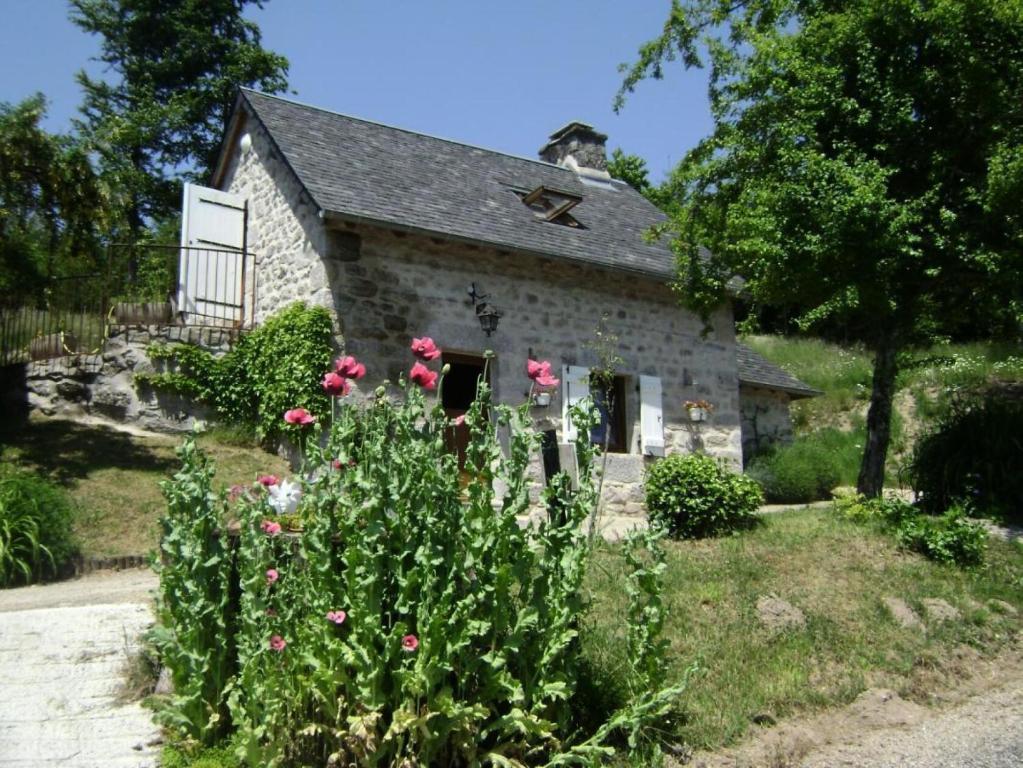 una casa de piedra con flores delante en Gîte de France à Chaveroche 2 épis - Gîte de France 2 personnes 664, 