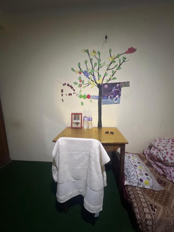 ein Zimmer mit einem Tisch mit einem Baum an der Wand in der Unterkunft Khatri Niwas in Tokna