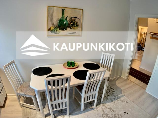 een witte tafel en stoelen in een kamer bij Kaupunkikoti in Kemi