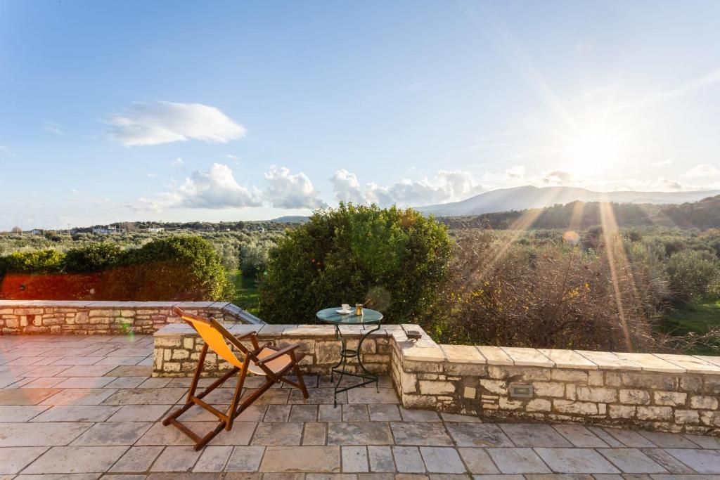 patio con mesa, sillas y vistas en Elaion Hideaway - Uncover Petalidi's Secrets, en Karpofóra