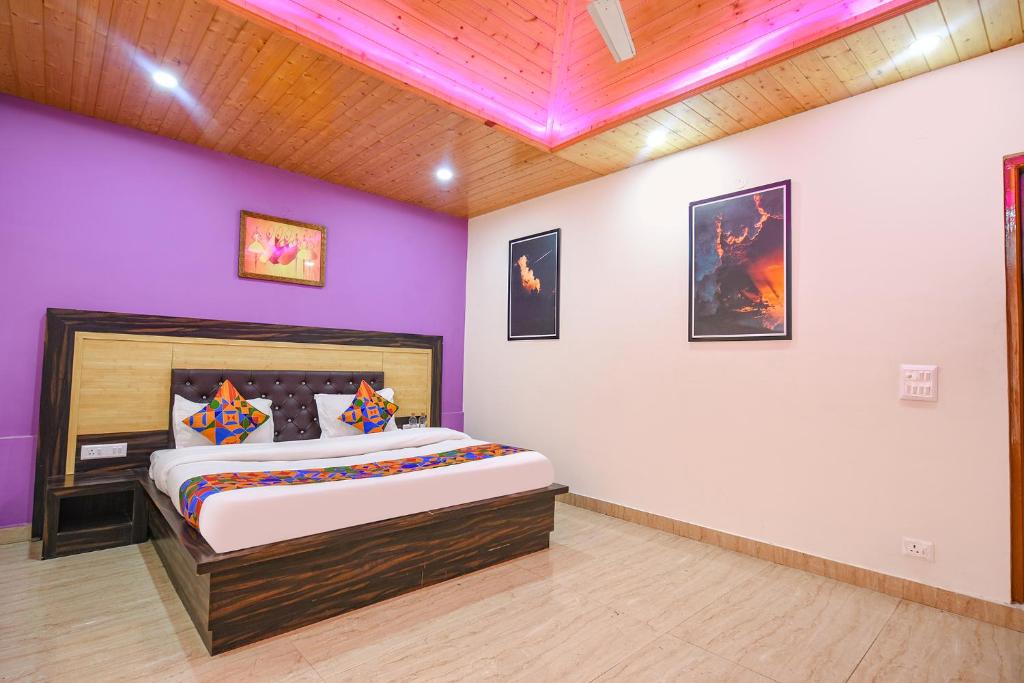 a bedroom with a large bed with purple walls at FabHotel The Kasauli Heavens in Kasauli
