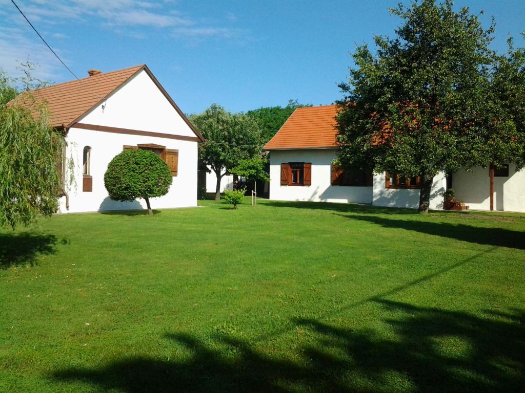 uma casa branca com um telhado laranja num quintal em Csendliget Vendégház em Geresdlak