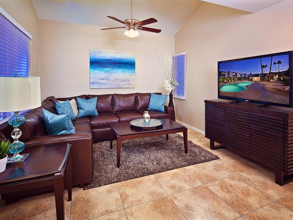 salon z brązową skórzaną kanapą i telewizorem z płaskim ekranem w obiekcie Scottsdale Vacation Rentals w mieście Scottsdale