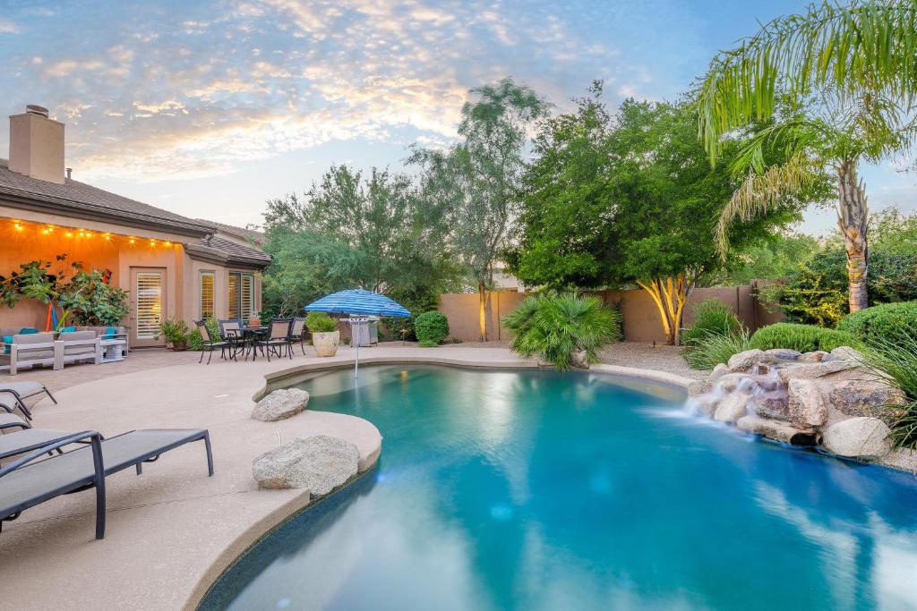 una piscina con cascada en un patio en Phoenix Vacation Rentals en Phoenix