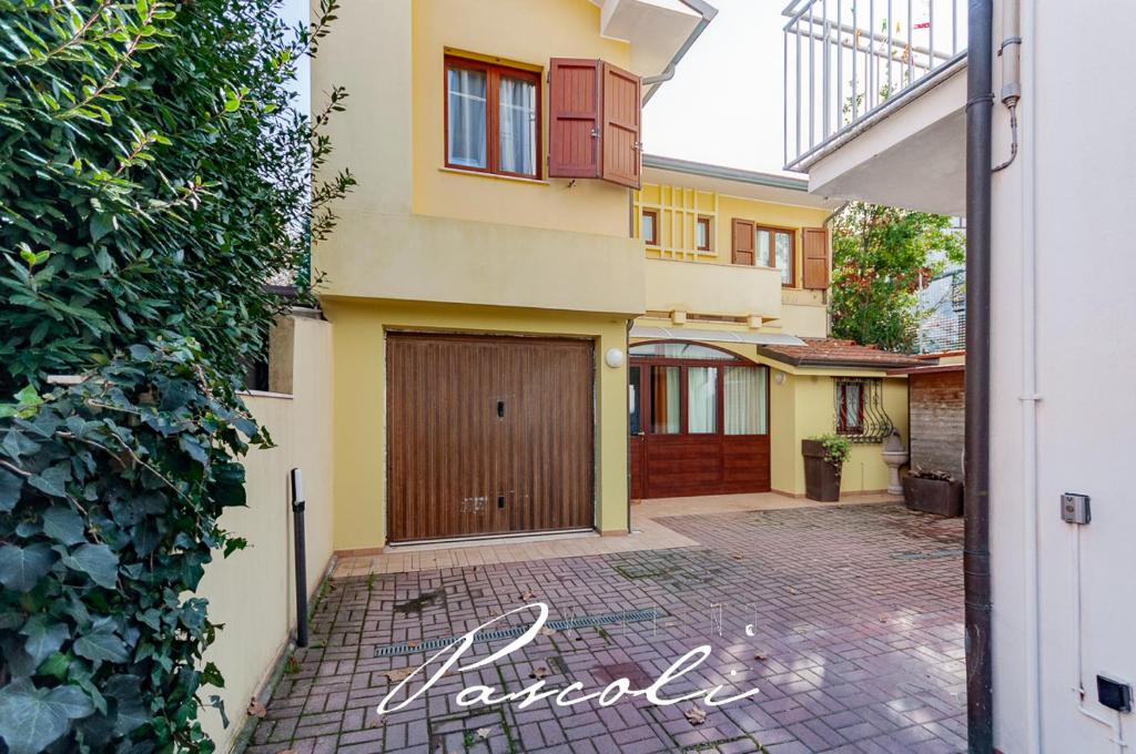 ein Haus mit einer Garage und einer Auffahrt in der Unterkunft Villino Pascoli (in centro storico) in Cesenatico