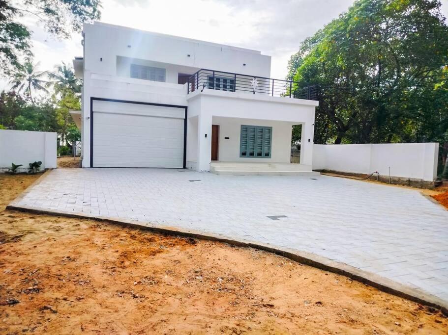 een groot wit huis met een grote garage bij Tropical oasis in Trivandrum