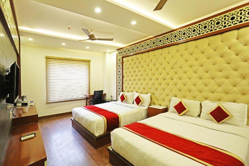 a bedroom with two beds and a large headboard at HOTEL MGM RESIDENCY in New Delhi