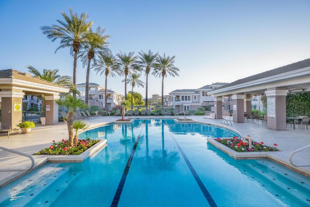 een zwembad in een resort met palmbomen bij Scottsdale Vacation Rentals in Scottsdale