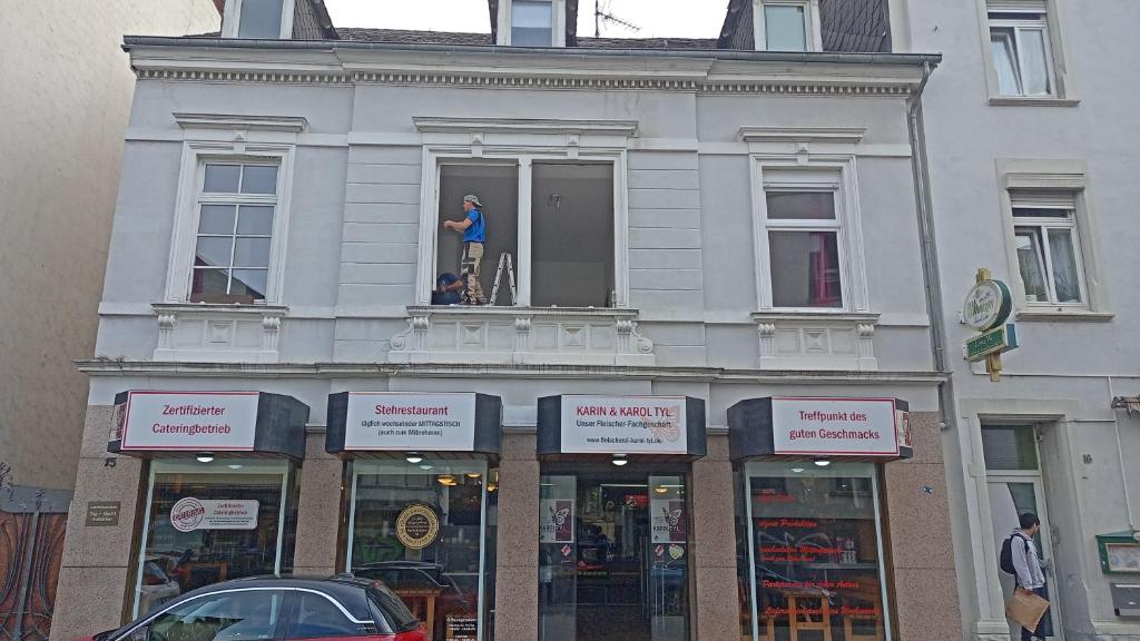 un homme debout dans la fenêtre d'un bâtiment dans l'établissement St Maximin City Ferienwohnungen, à Trèves