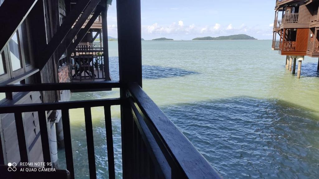 uma vista para o oceano a partir de uma varanda em Villa Dalam Laut 580 em Pantai Cenang