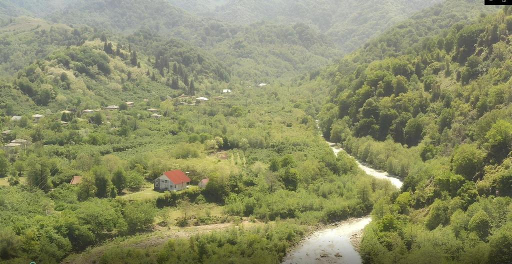 una valle di montagna con una casa e un fiume di SIO Marani a Gomi