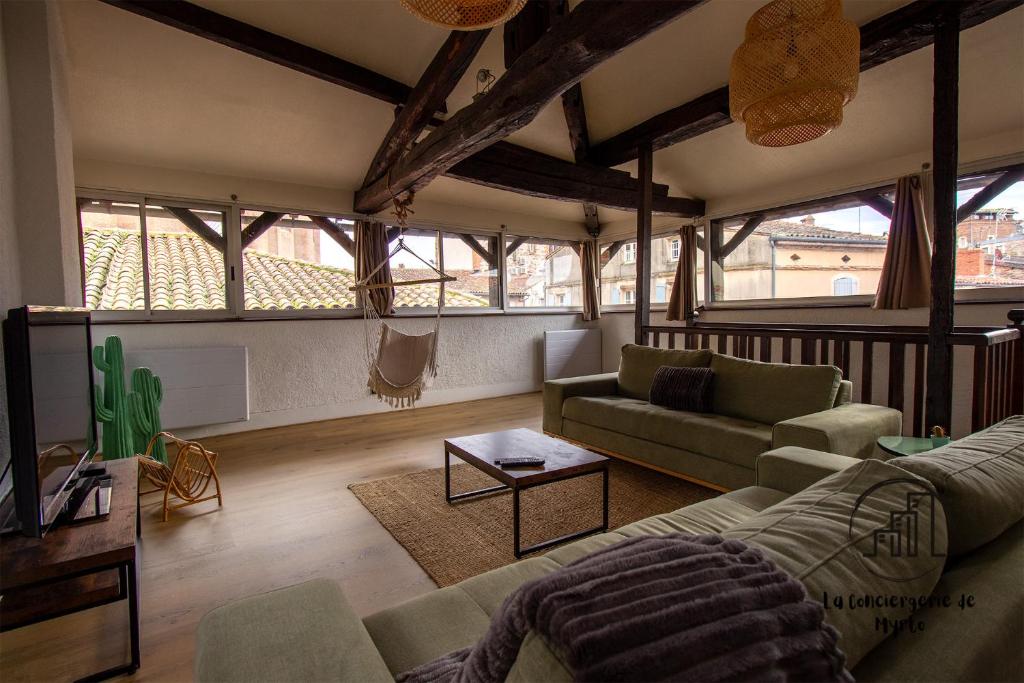 a living room with a couch and a table at Sous les toits de Sainte-Cécile in Albi