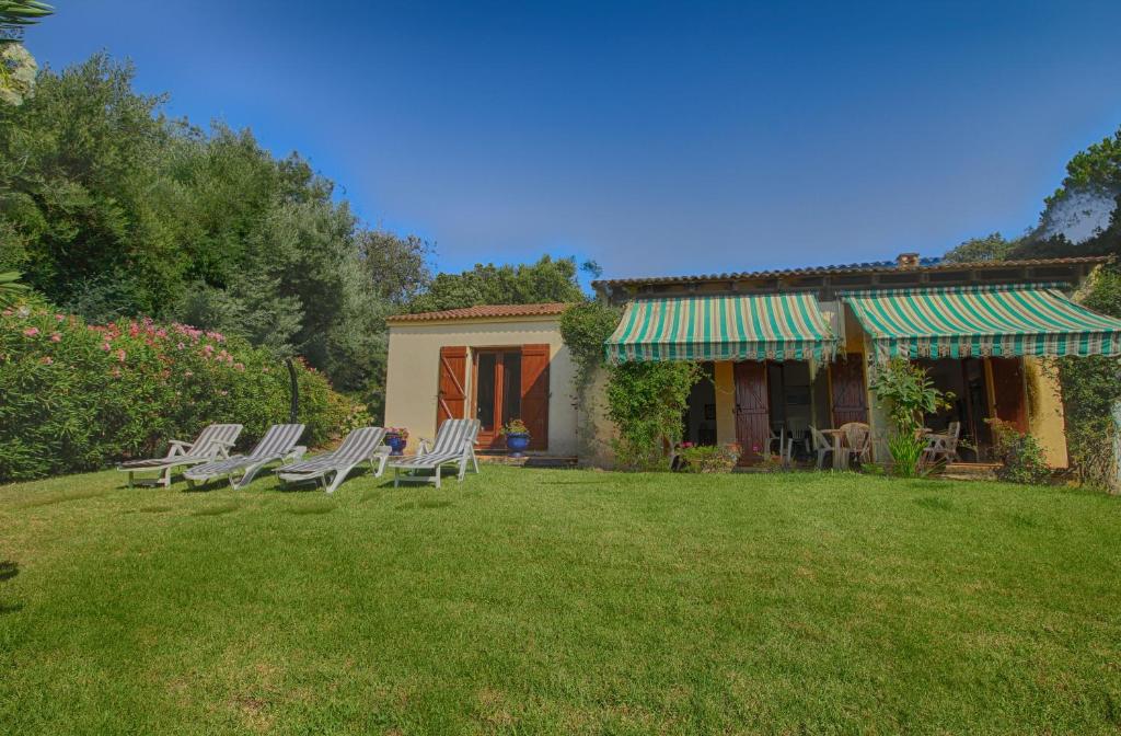 un groupe de chaises assises dans la cour d'une maison dans l'établissement VILLA 200 m de la plage La Liscia TIUCCIA, à Casaglione