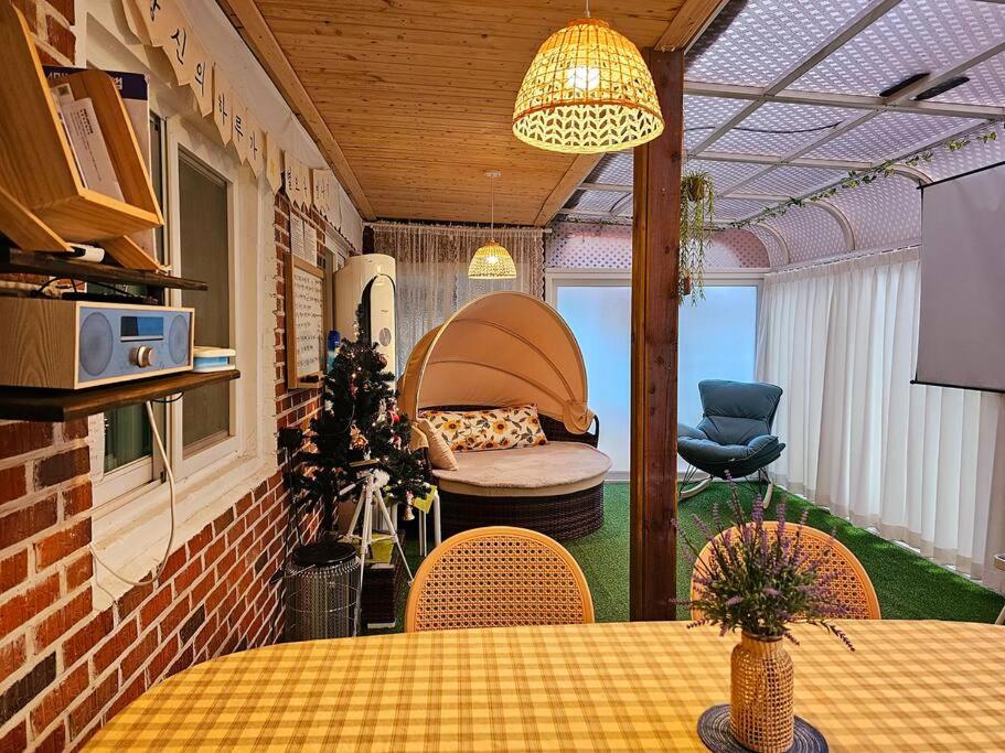 Zimmer mit einem Tisch, Stühlen und einem Sofa in der Unterkunft Hello minbak in Boseong