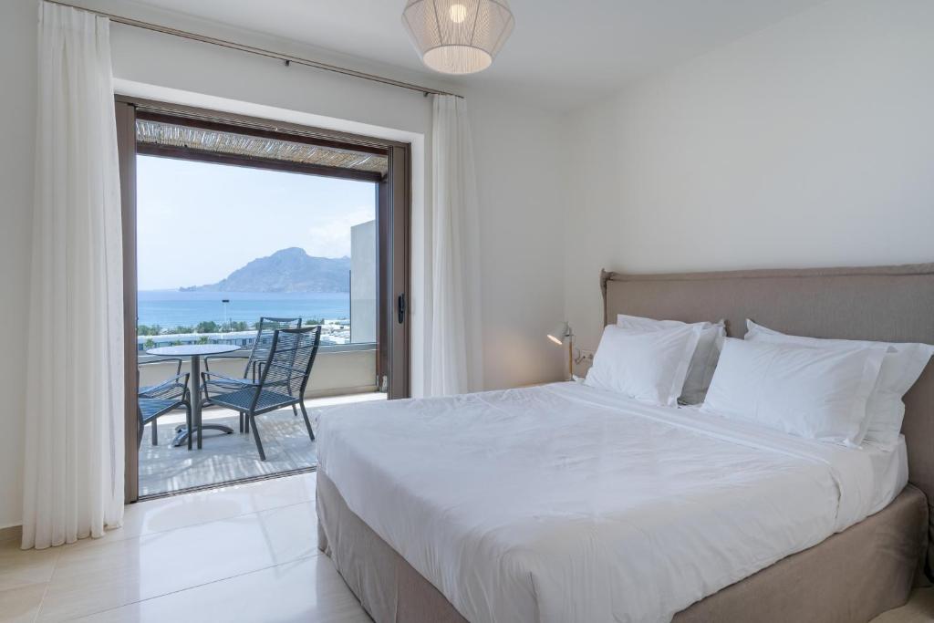 a bedroom with a bed and a view of the ocean at Plakias Resorts in Plakias