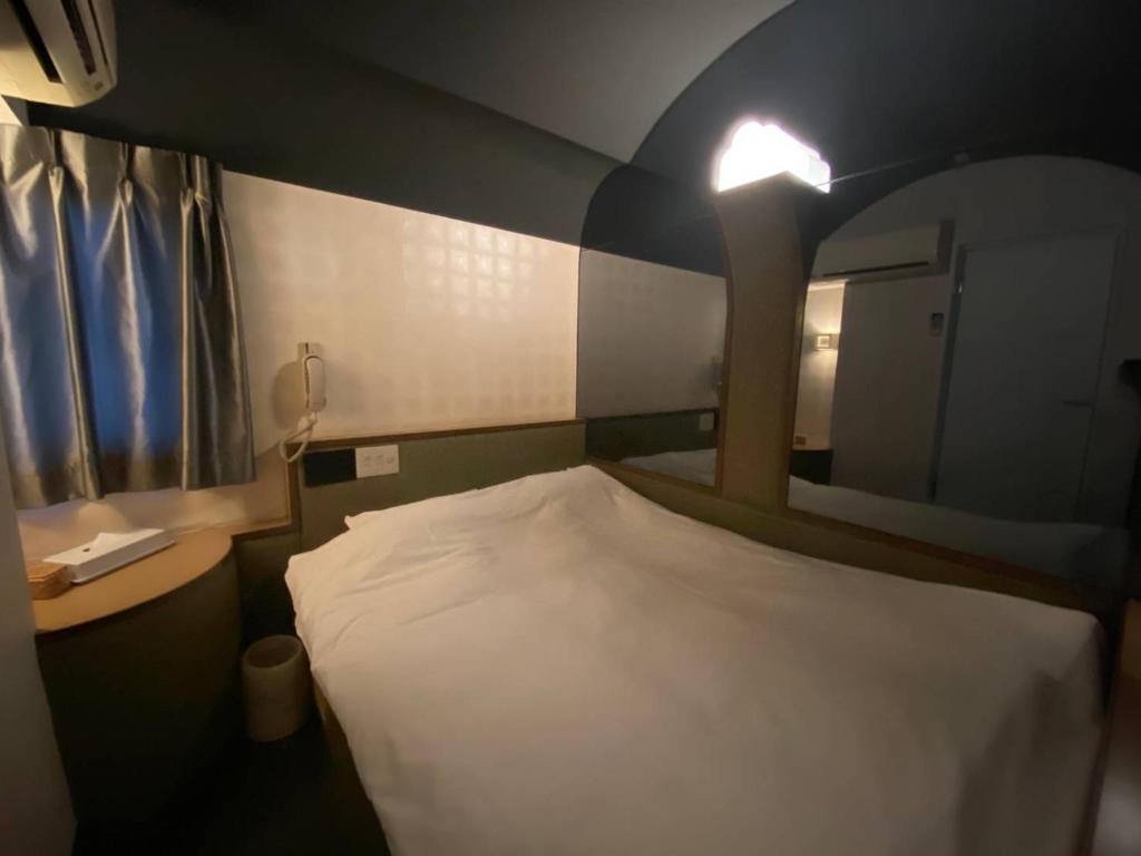 Postel nebo postele na pokoji v ubytování ラグナイン 八王子 Laguna inn