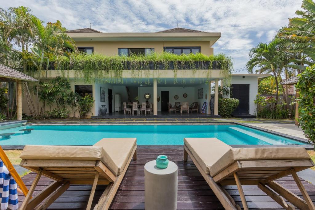 a villa with a swimming pool and a house at Beautiful Huge 4 bedrooms Villa in Canggu in Canggu