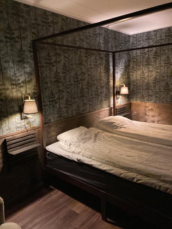 um quarto com uma cama e duas lâmpadas na parede em Hotell Stensborg em Skelleftea