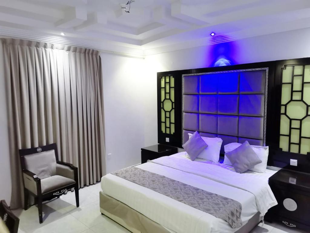 a bedroom with a large bed and a chair at Golden New Al Dar - جولدن نيو الدار in Jazan