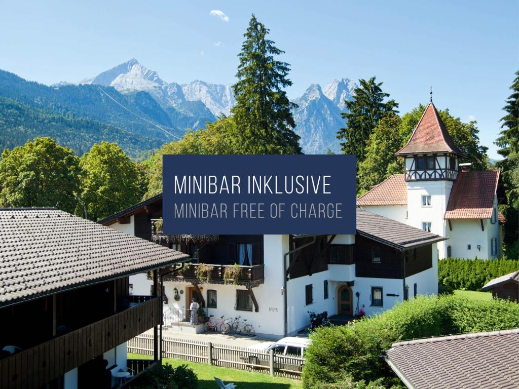 un cartello che legge vino gratuito di fronte a un edificio di HYPERION Hotel Garmisch - Partenkirchen a Garmisch-Partenkirchen