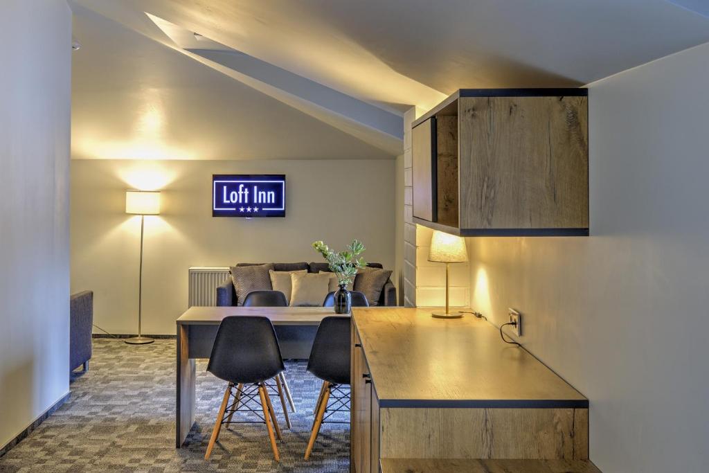 sala de estar con mesa y sillas en Loft Inn SELF-CHECK IN en Vilna