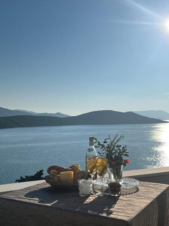 a table with a basket of bread and a bottle of wine at Villa Grande in Neum