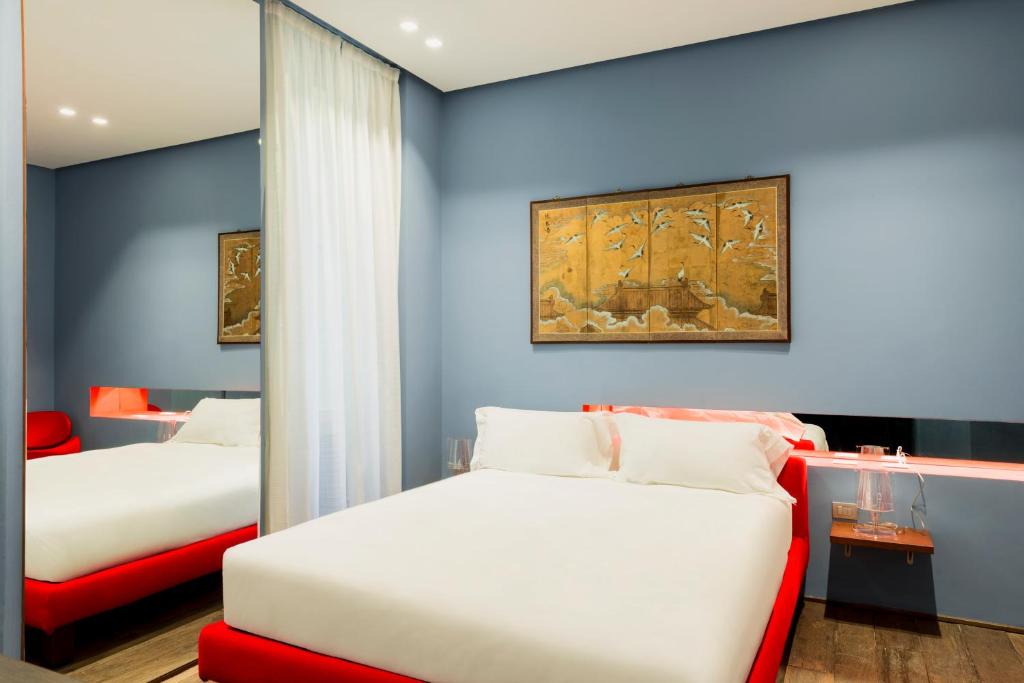 a bedroom with two beds and a painting on the wall at Palazzo Segreti in Milan