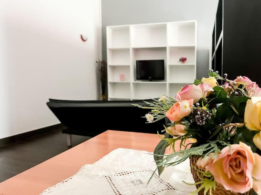 eine Vase mit Blumen auf einem Tisch im Wohnzimmer in der Unterkunft Mini Appartamento Cutura Rende in Rende