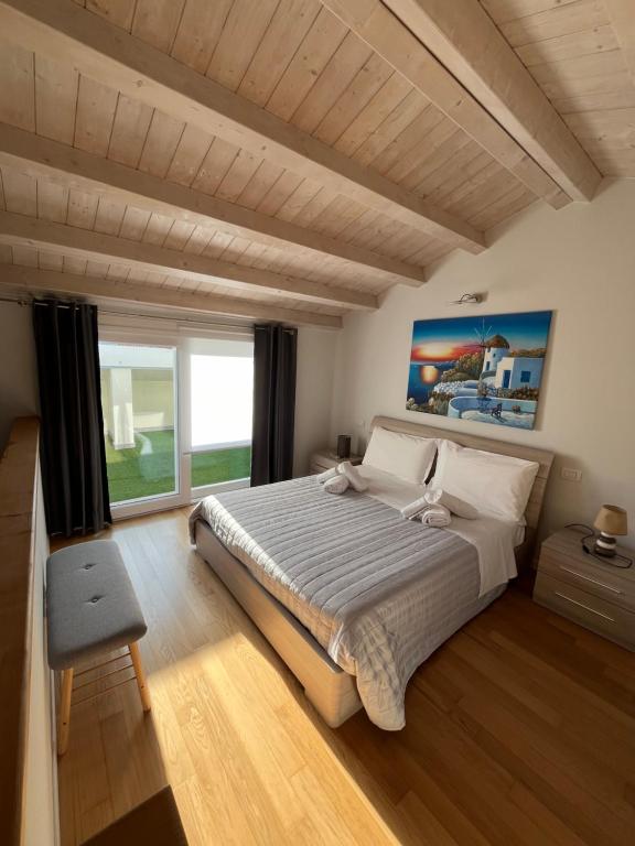 um quarto com uma cama grande e uma janela grande em La Darsena apartment em Peschiera del Garda