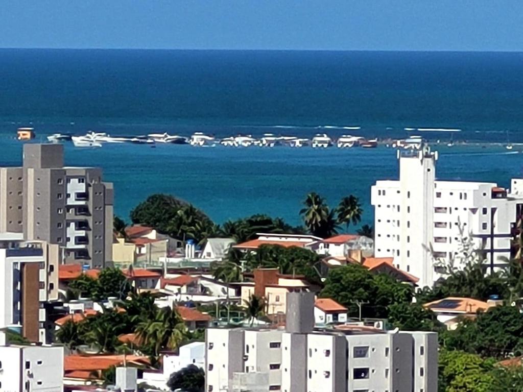 - une vue sur la ville avec ses bâtiments et l'océan dans l'établissement Apartamento em Ponta de Campina a 600m da praia, à Cabedelo