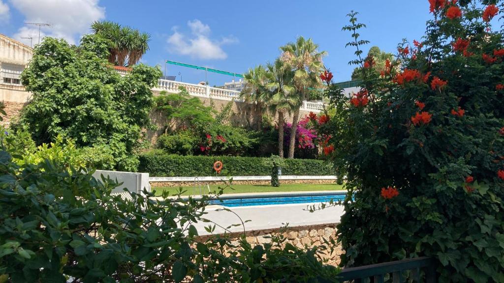 a swimming pool in a garden with trees and flowers at La Carihuela in Torremolinos