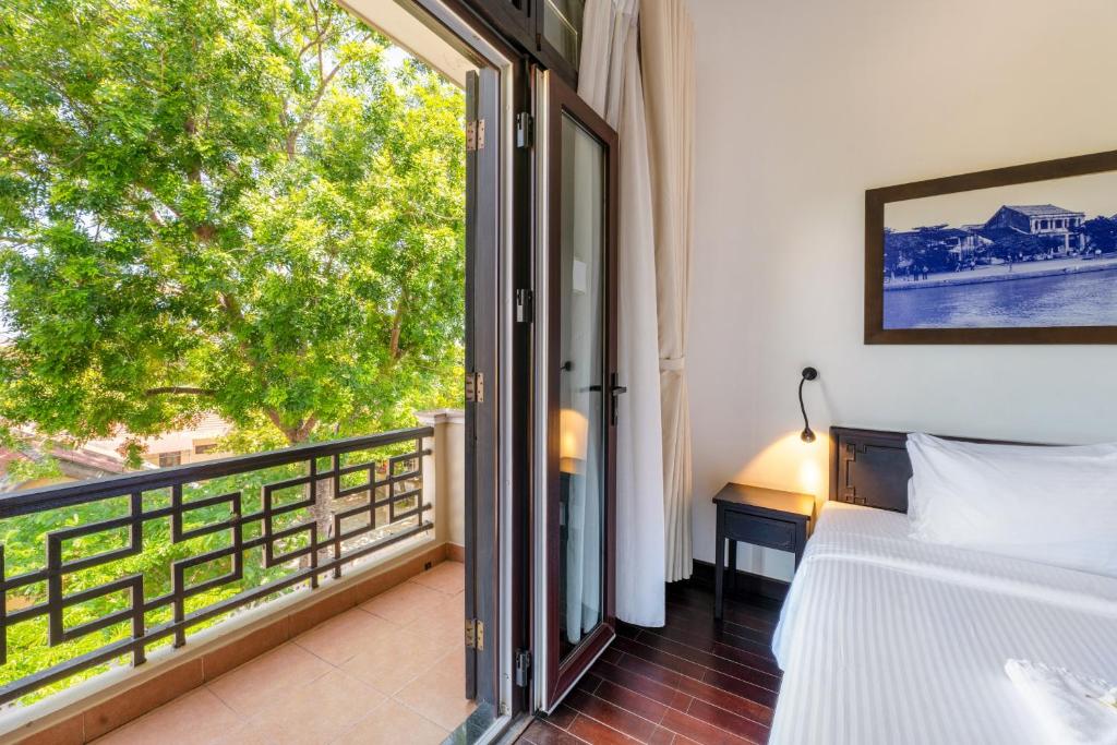Giường trong phòng chung tại HOI AN HISTORIC HOTEL