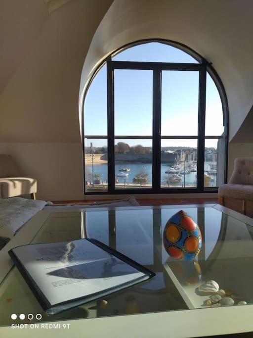 Cette chambre comprend une table en verre avec un ballon de football. dans l'établissement LOFT face à la ville Close Concarneau, à Concarneau
