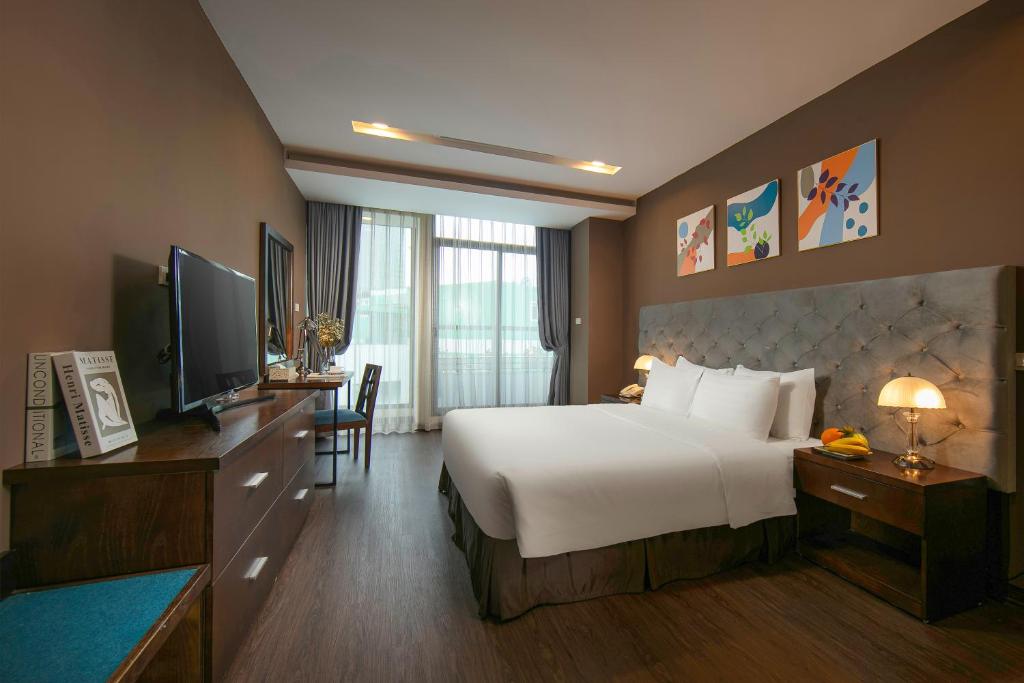 a hotel room with a large bed and a television at Brilliant Me Tri Hotel & Spa in Hanoi