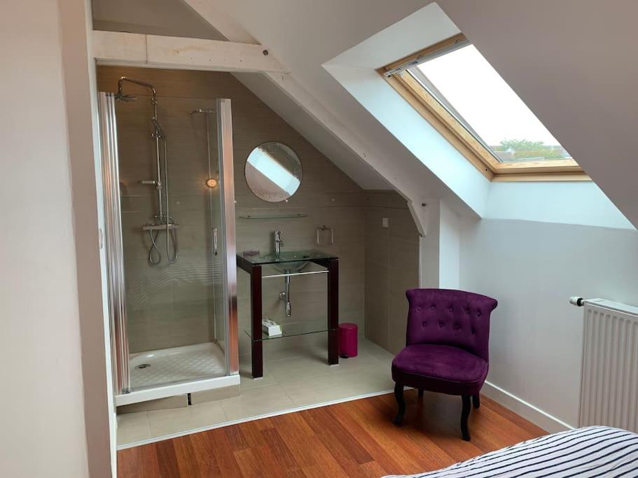 a bathroom with a shower and a purple chair at LOFT face à la ville Close Concarneau in Concarneau