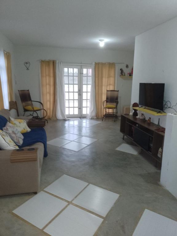 sala de estar con sofá y TV en Casa aconchegante e ampla, en Garanhuns
